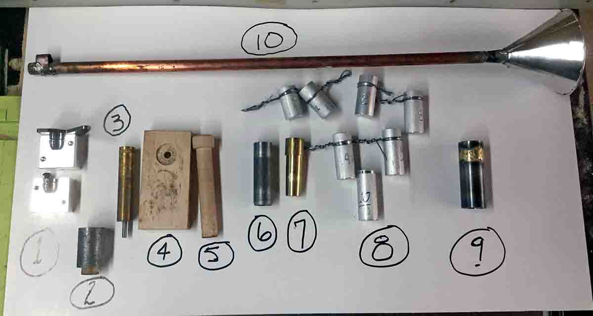 A collection of homemade 8-bore loading tools. 1. Accurate Molds Paradox mold, 2. Bullet sizing die, 3. Primer removing punch, 4. Maple block for removing and seating primers, 5. Maple punch for seating primers and wads, 6. Lube cutter to remove bullets from lube pan, 7. Tapered punch to remove crimp from case, 8. Various powder measures, 9. Case crimping die, 10. Powder drop tube. All of these go to the gun owner when the project is done, along with instructions.